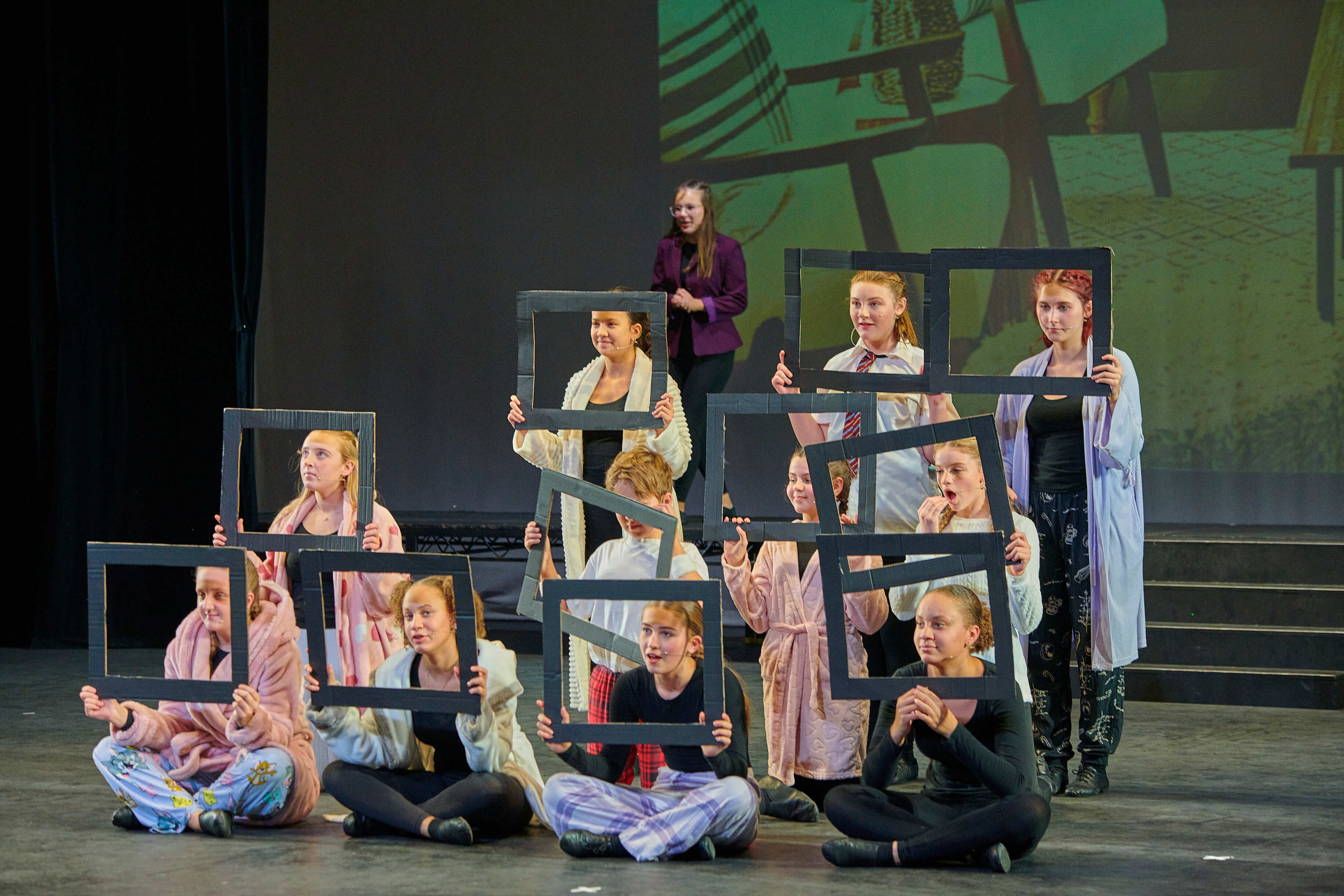 Dreams students acting together with picture-frame props